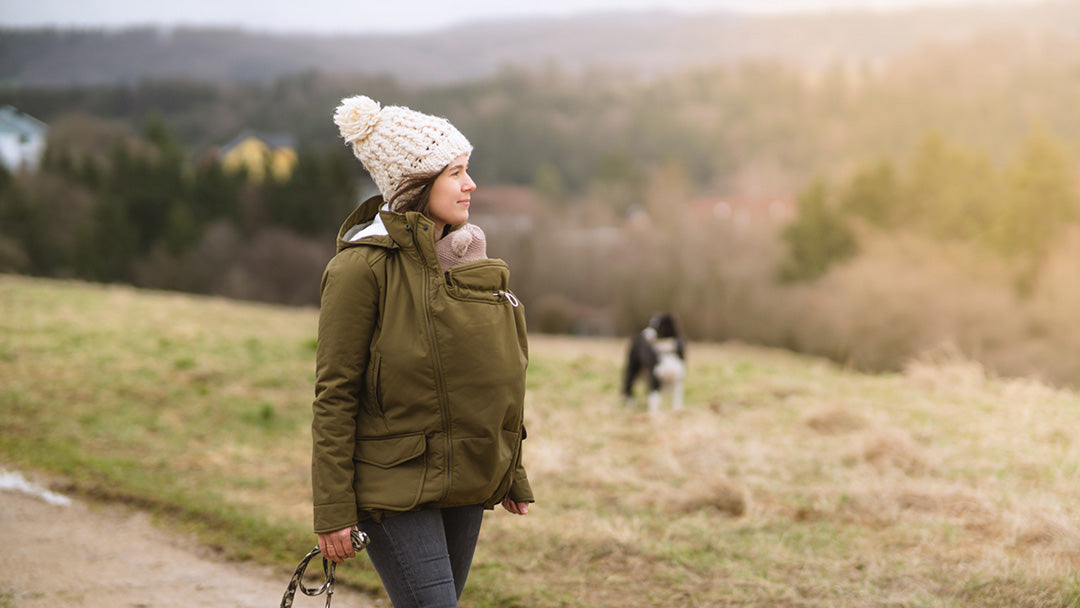 Woman carrying her baby in a Mamalila babywearing coat