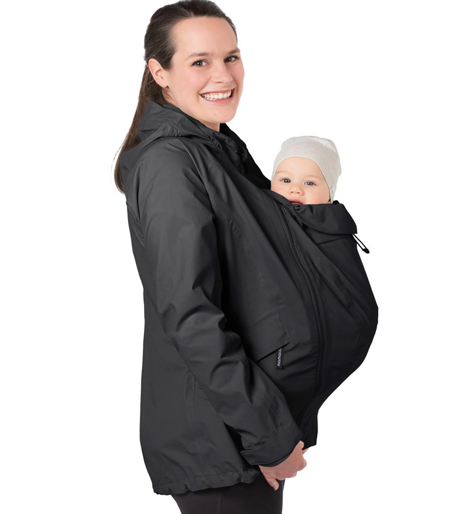 A person wearing the Mamalila Outdoor Explorer Babywearing Jacket - Black