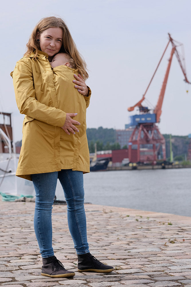 Mamalila Dublin Babywearing Rain Coat in Mustard. A sustainably made babywearing rain coat in mustard yellow. Side view