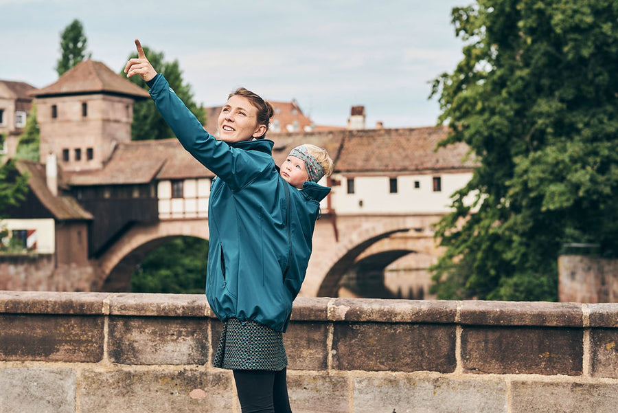 Mamalila Teal Softshell Babywearing Jacket Allrounder being worn whilst back carrying a baby
