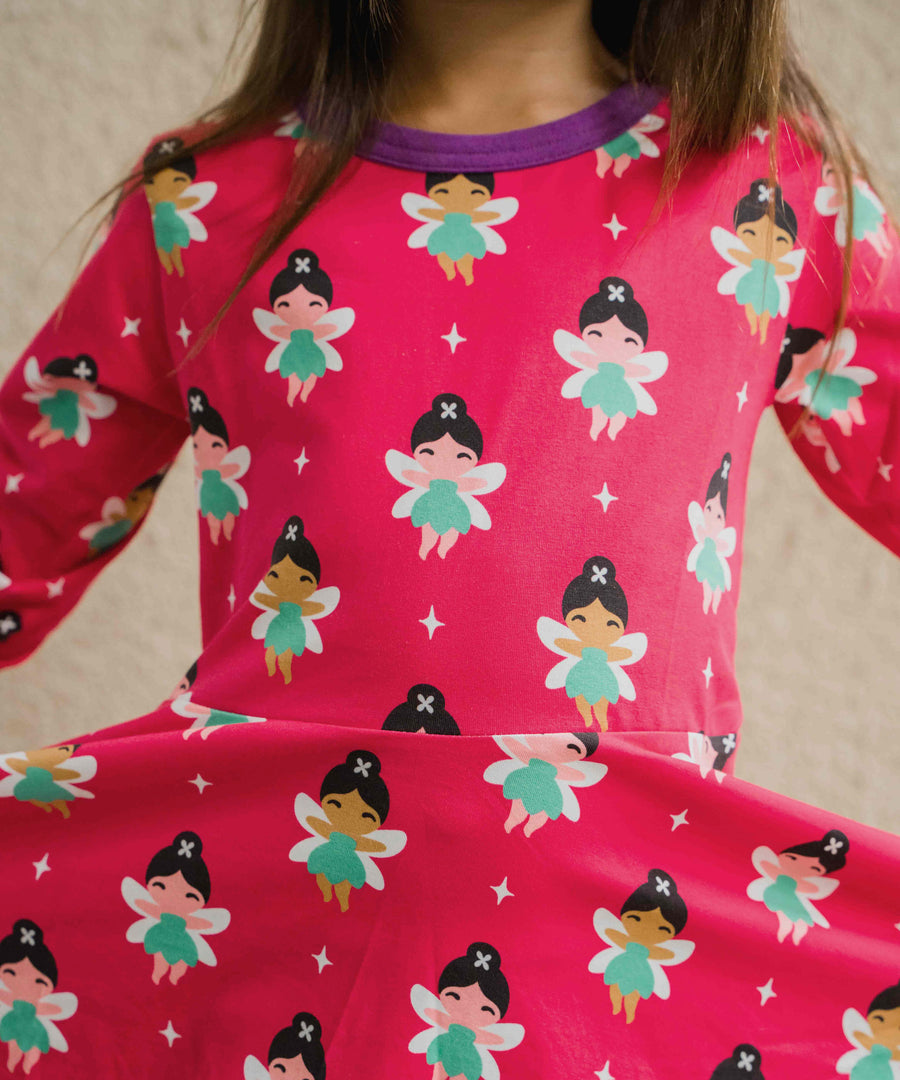 A close up of a child wearing the Maxomorra Fairy print circle. dress.