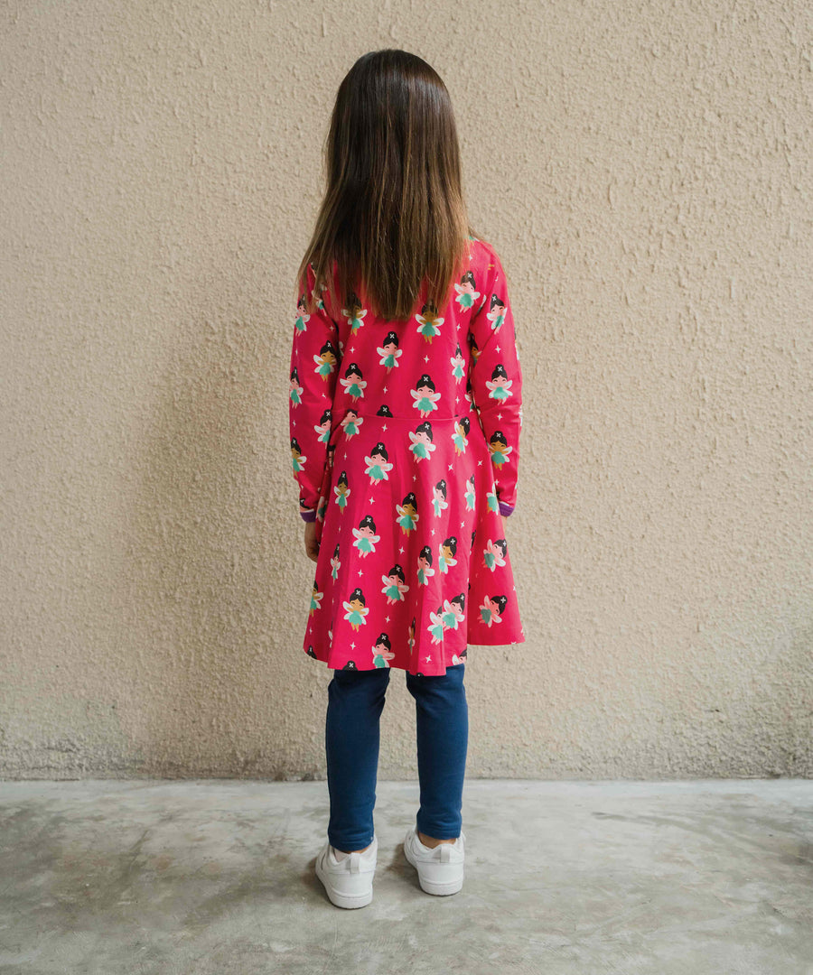 A child wearing the Maxomorra Fairy print circle dress. The child is facing away from the camera showing the back of the dress. 