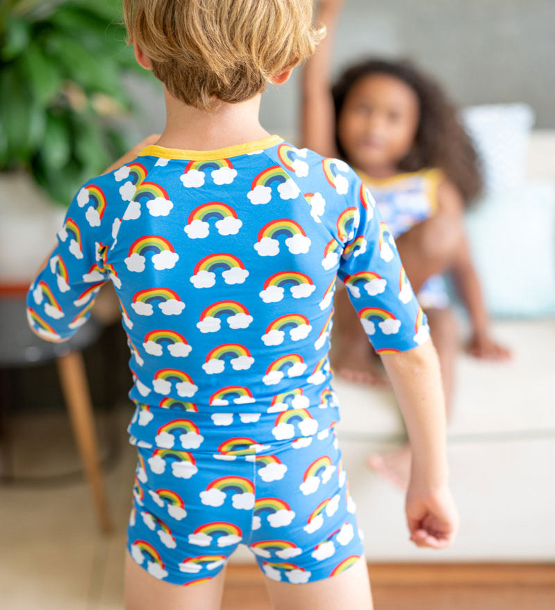 View of child from behind wearing the Maxomorra Rainbow Swim Top with matching swim trunks