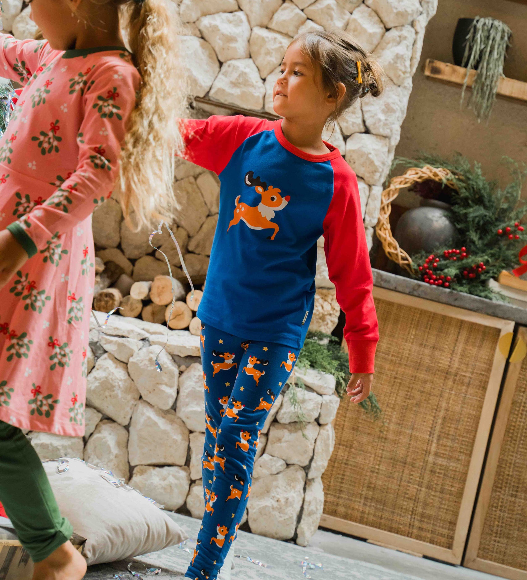 A child wearing the Maxomorra Reindeer Leggings with a coordinating reindeer print raglan top. 