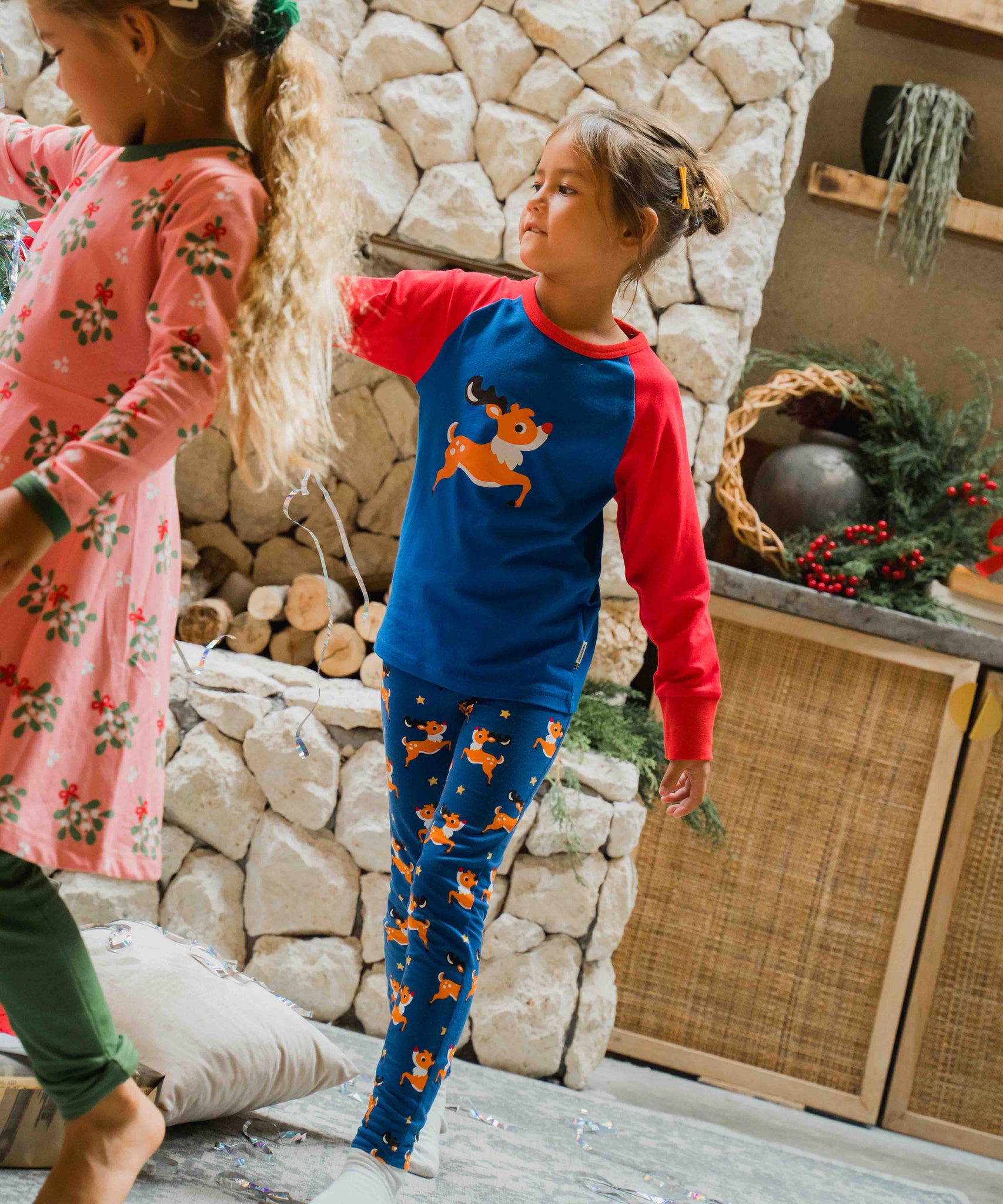 A child wearing the Maxomorra Reindeer Leggings with a coordinating reindeer print raglan top. 