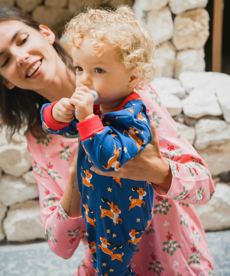 A young child wearing the Maxomorra Reindeer Long Sleeve Rompersuit.