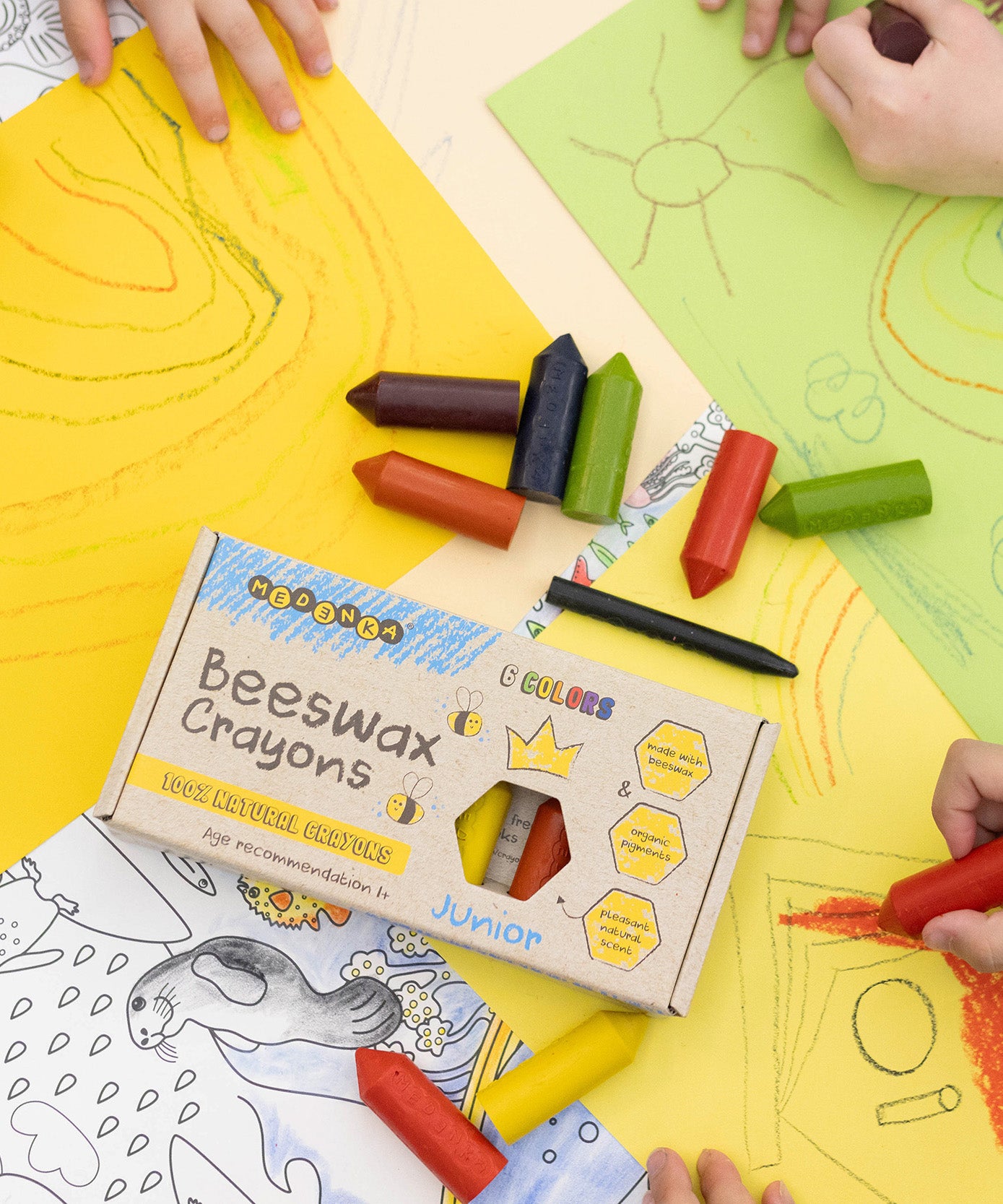 Children's hands using the Medenka junior beeswax crayons to colour in.