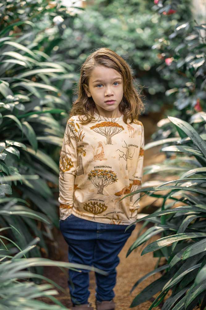  giraffes and tree names repeat print. Worn by child with long hair