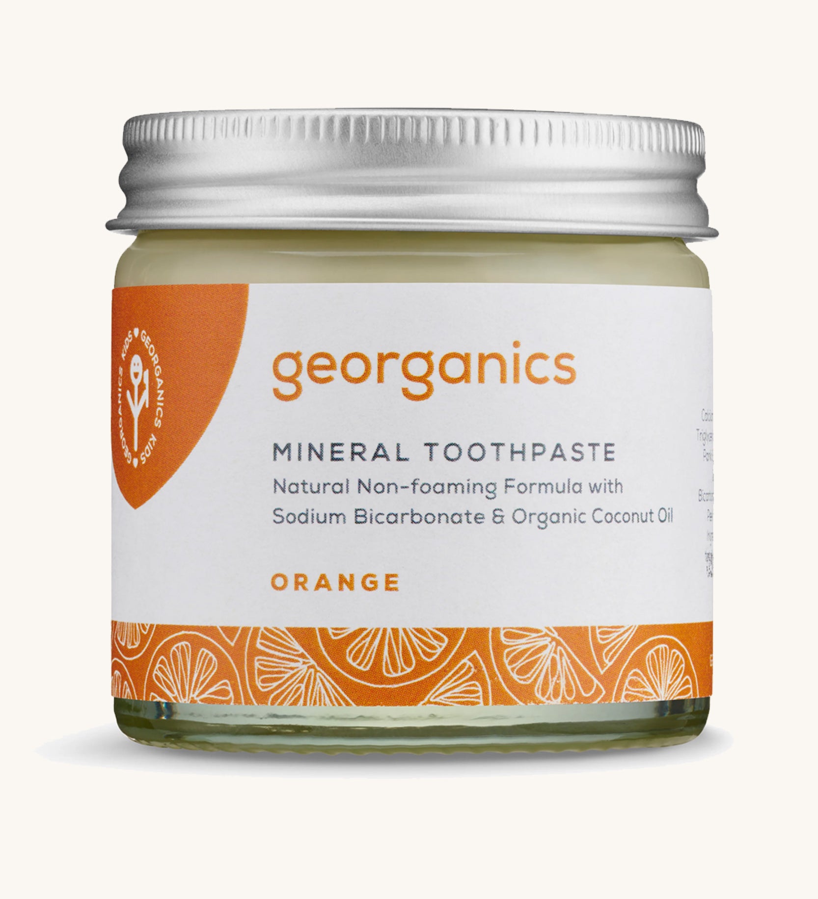 A jar of the Georganics orange mineral toothpaste on a cream background