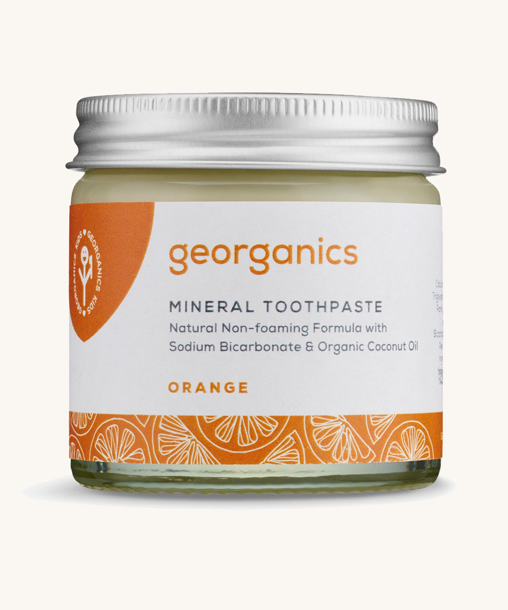 A jar of the Georganics orange mineral toothpaste on a cream background