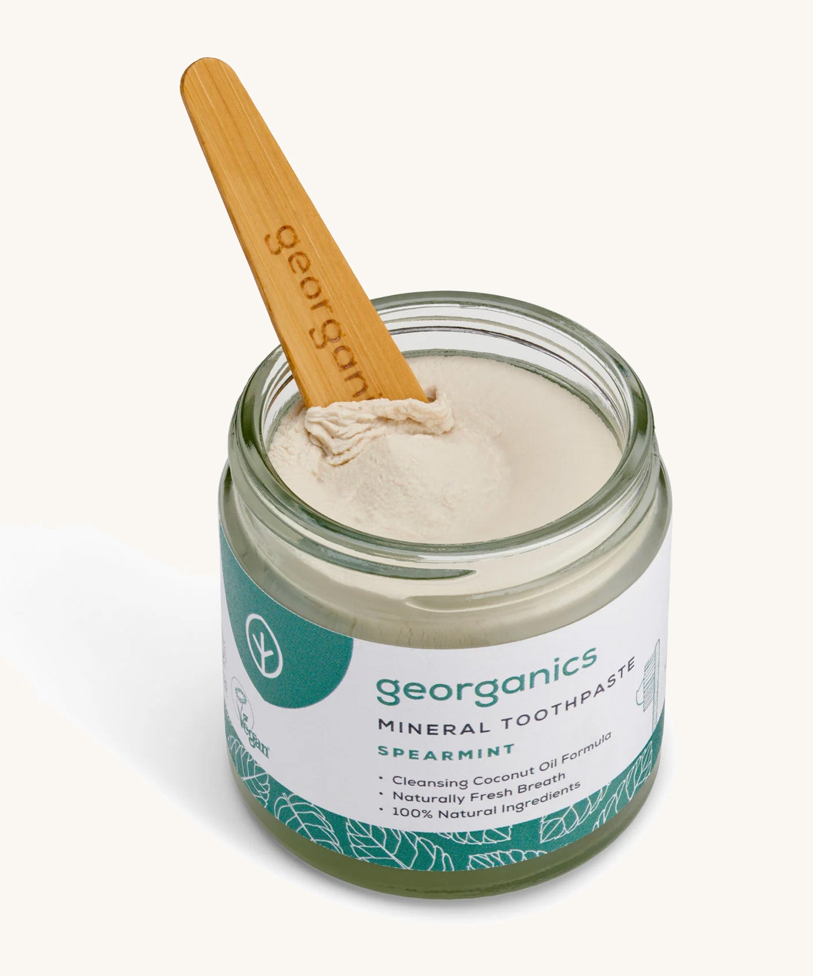 A opened jar of the Georganics spearmint mineral toothpaste on a cream background.