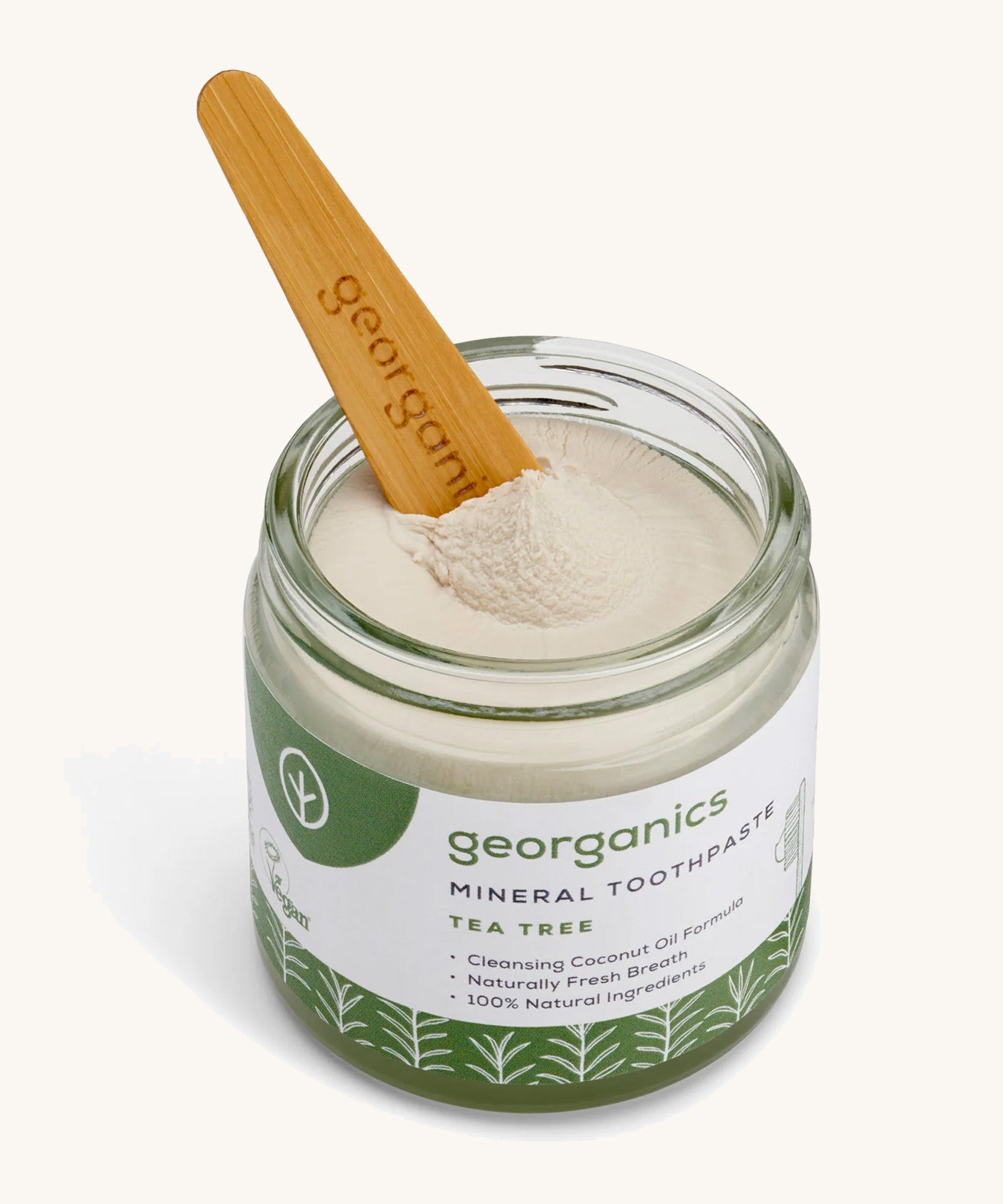 A opened jar of the Georganics tea tree mineral toothpaste with the tongue stick dipped in.