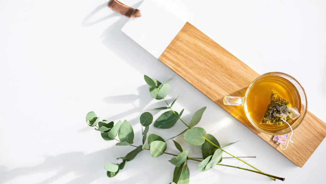 A wooden tray with a mug of natural Myrtle & Maude herbal wellness tea