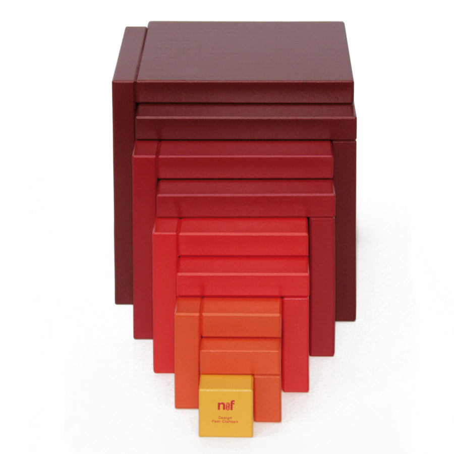 Naef Cella Stacking Cube in a red colour shown with pieces stacked up