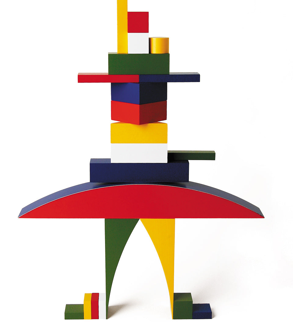 Naef Bauhaus building blocks stacked into a person shape on a white background