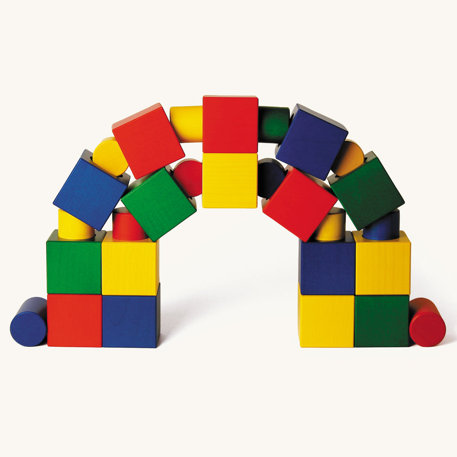 Naef plastic-free wooden Ligno blocks made into an arch shape on a beige background