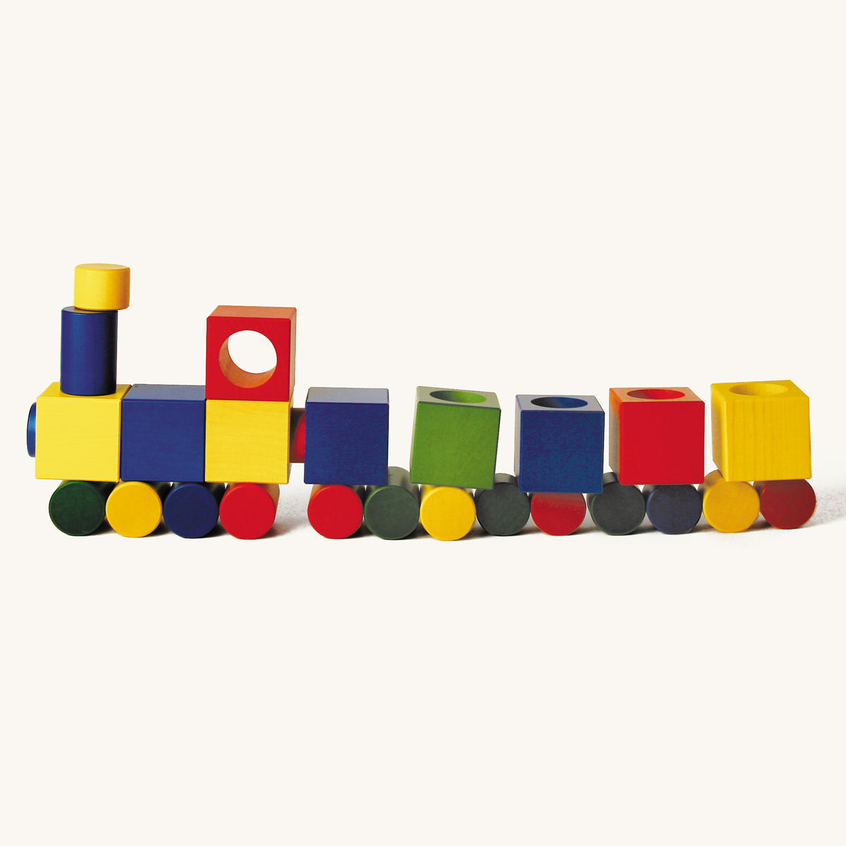 Naef premium wooden Ligno blocks set laid out in a train shape on a beige background