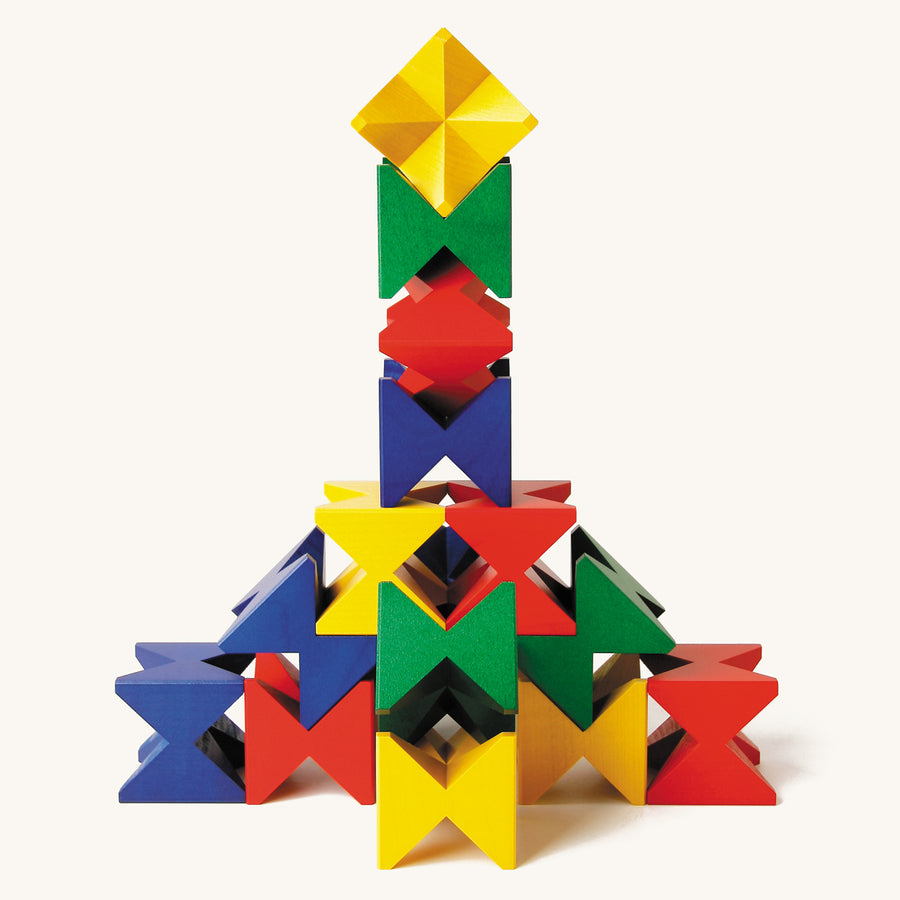 Naef Spiel premium wooden stacking toy blocks stacked in a pyramid on a beige background