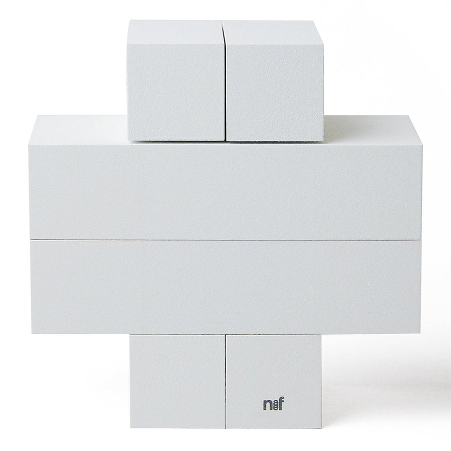 4 identical pieces of Naef's Quadrigo wooden toy slotted together to make a cross shape on a white background.