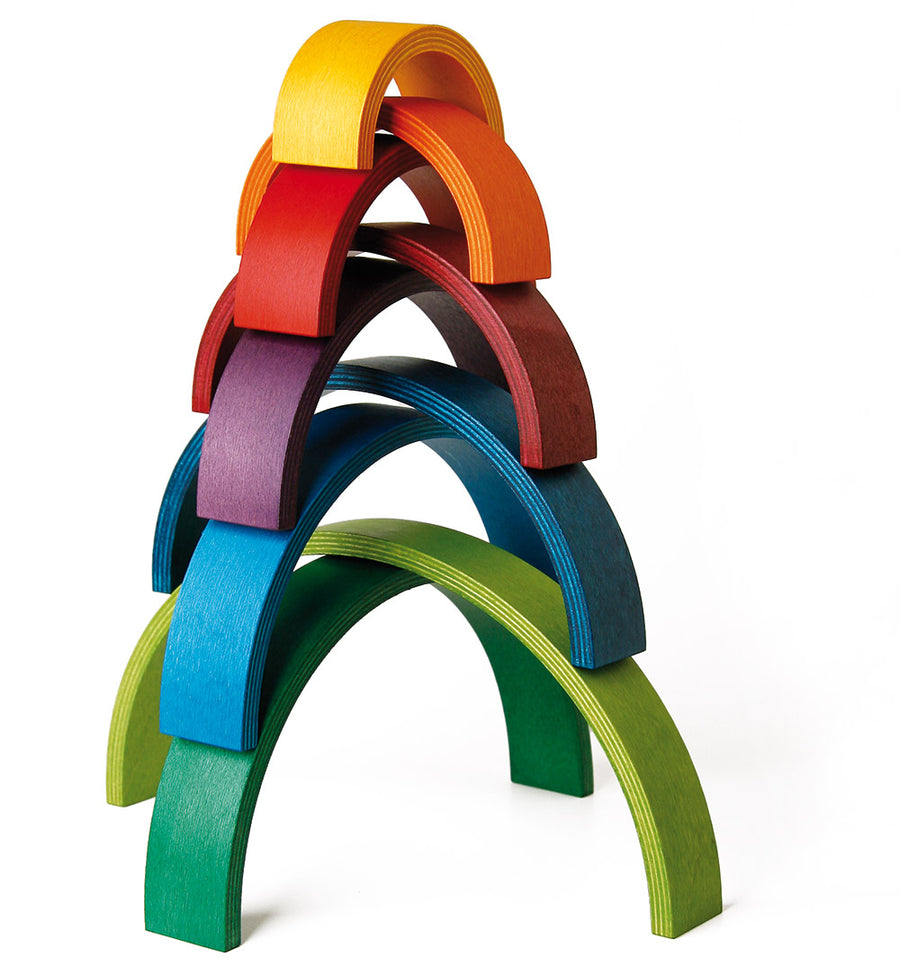 9 arches of Naef's wooden rainbow toy upturned in a half pipe shape