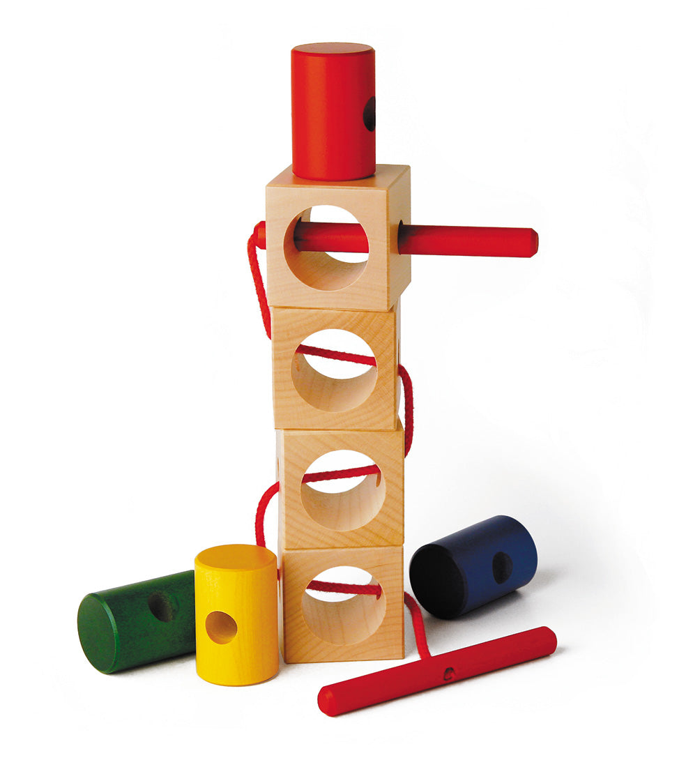 Naef Signa wooden threading stacked in a tower on a white background. Shows 4 wooden cubes stacked with 4 cyclinders surrounding tower. Thread is woven between all 4 cubes.