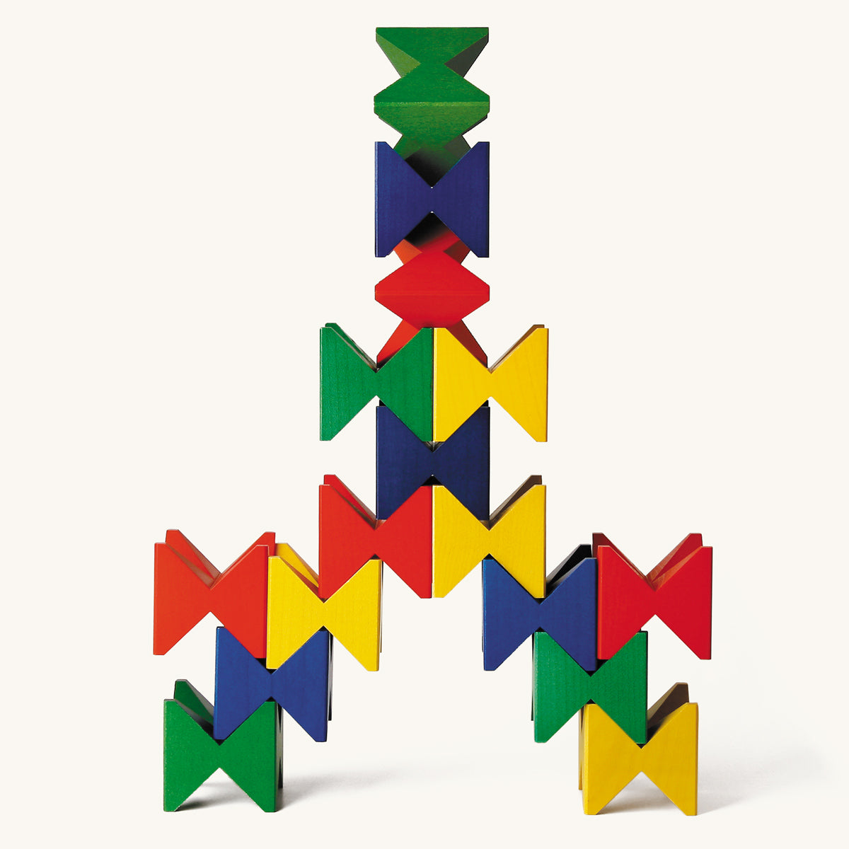 Naef Spiel angular wooden toy blocks stacked in a tower on a beige background