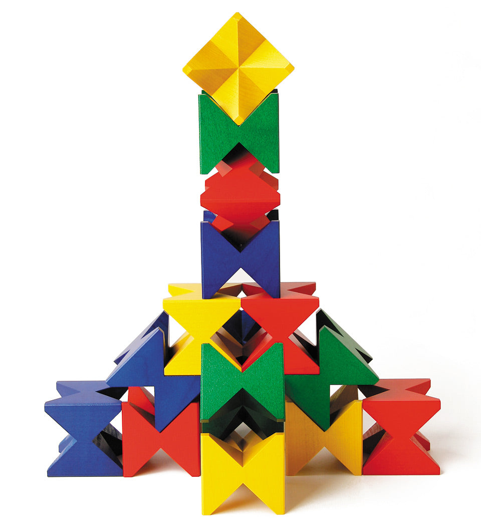 Naef Spiel wooden construction blocks stacked in a geometric tower on a white background