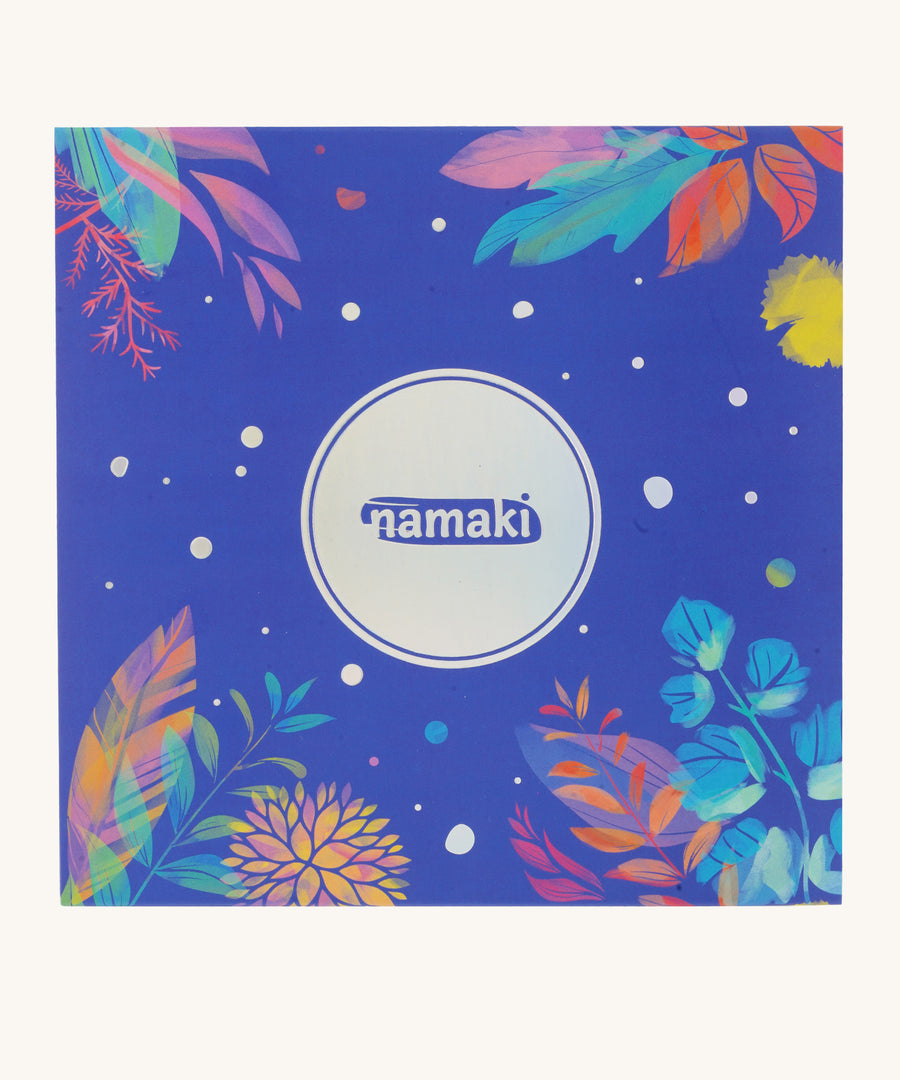 An closed blue cardboard box for the Namaki fairy moonlight make up set which has multicoloured leaves and flowers on a cream background.