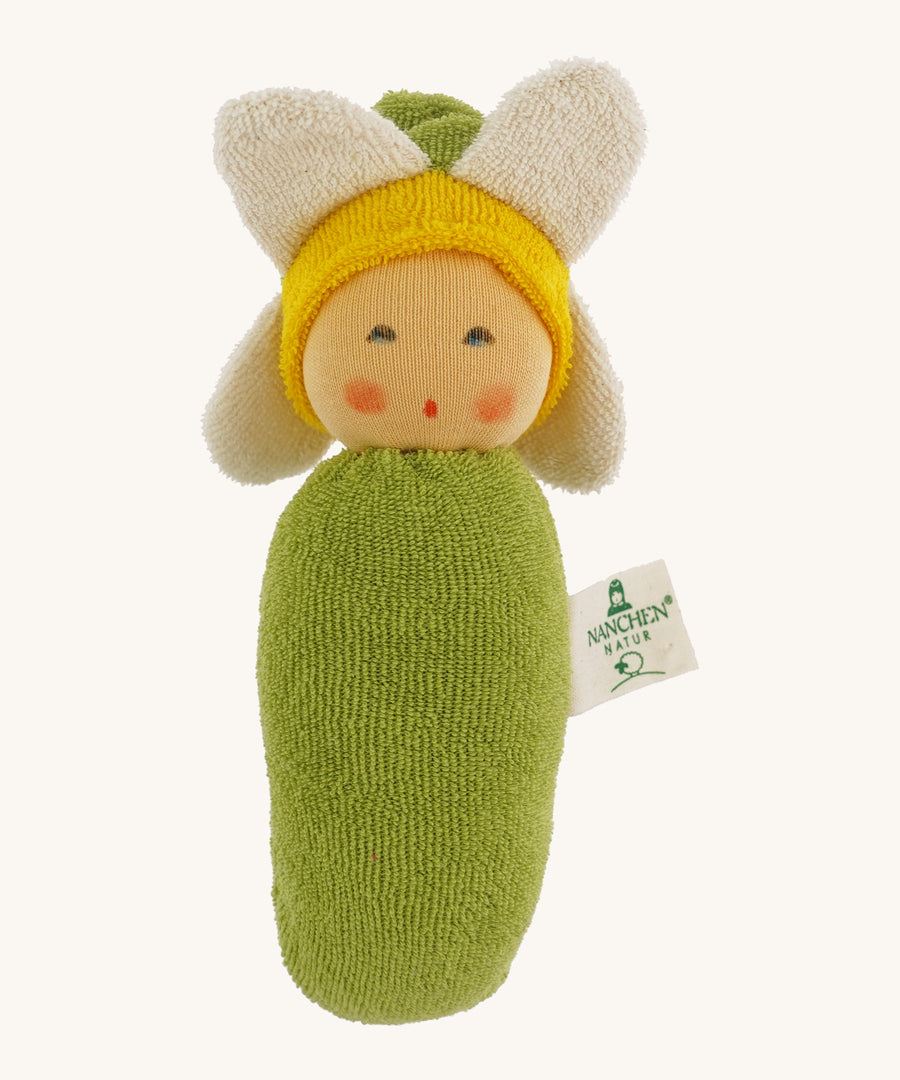 Nanchen Flower Rattle Doll - Daisy, is a soft, organic and handmade sensory doll toy with a green body, a little greet hat with white daisy leaves and a yellow strip of fabric to mimic hair. This doll also has an adorable face with green eyes