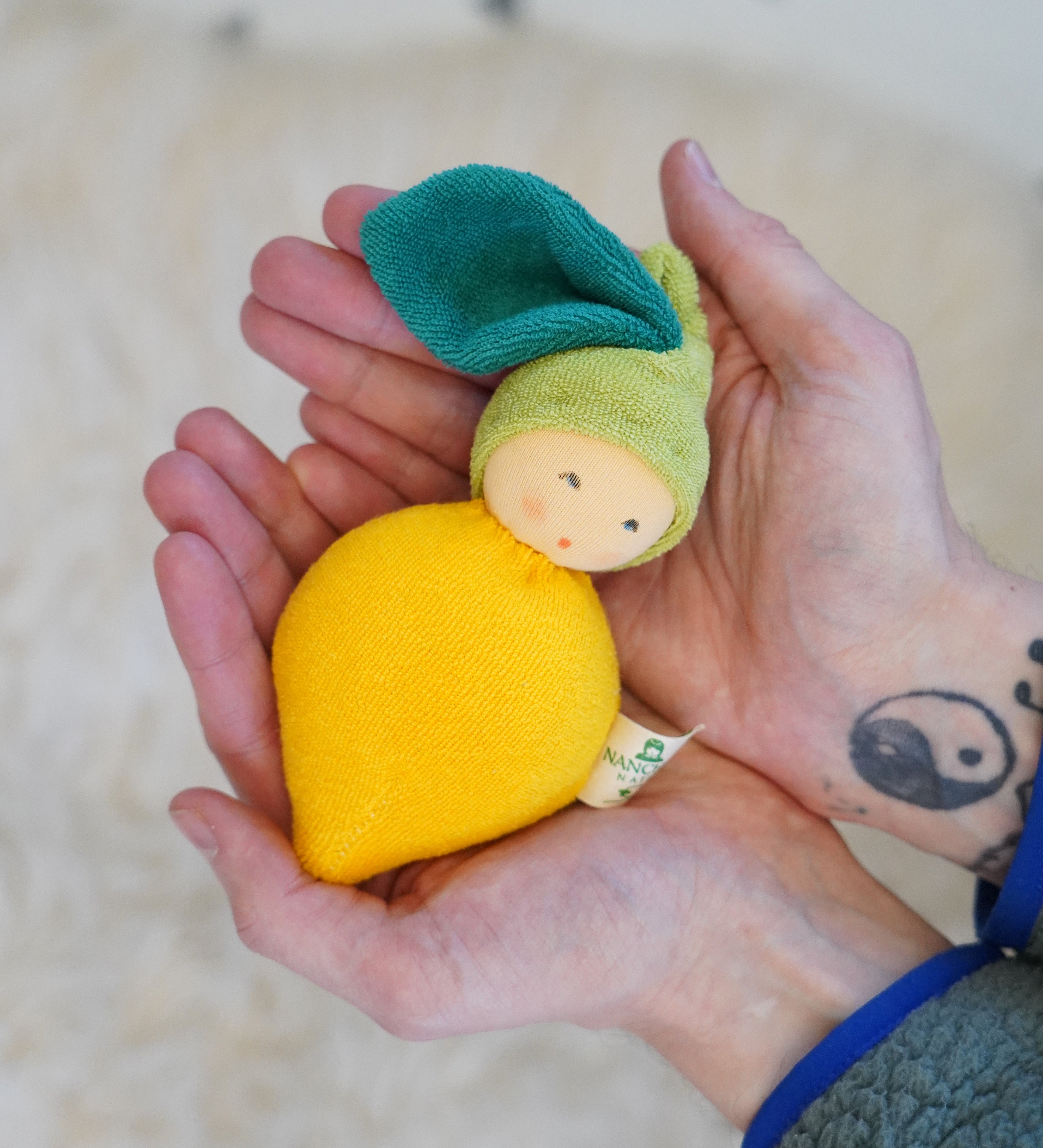 Nanchen Lemon Rattle Doll - organic doll in a persons hands.