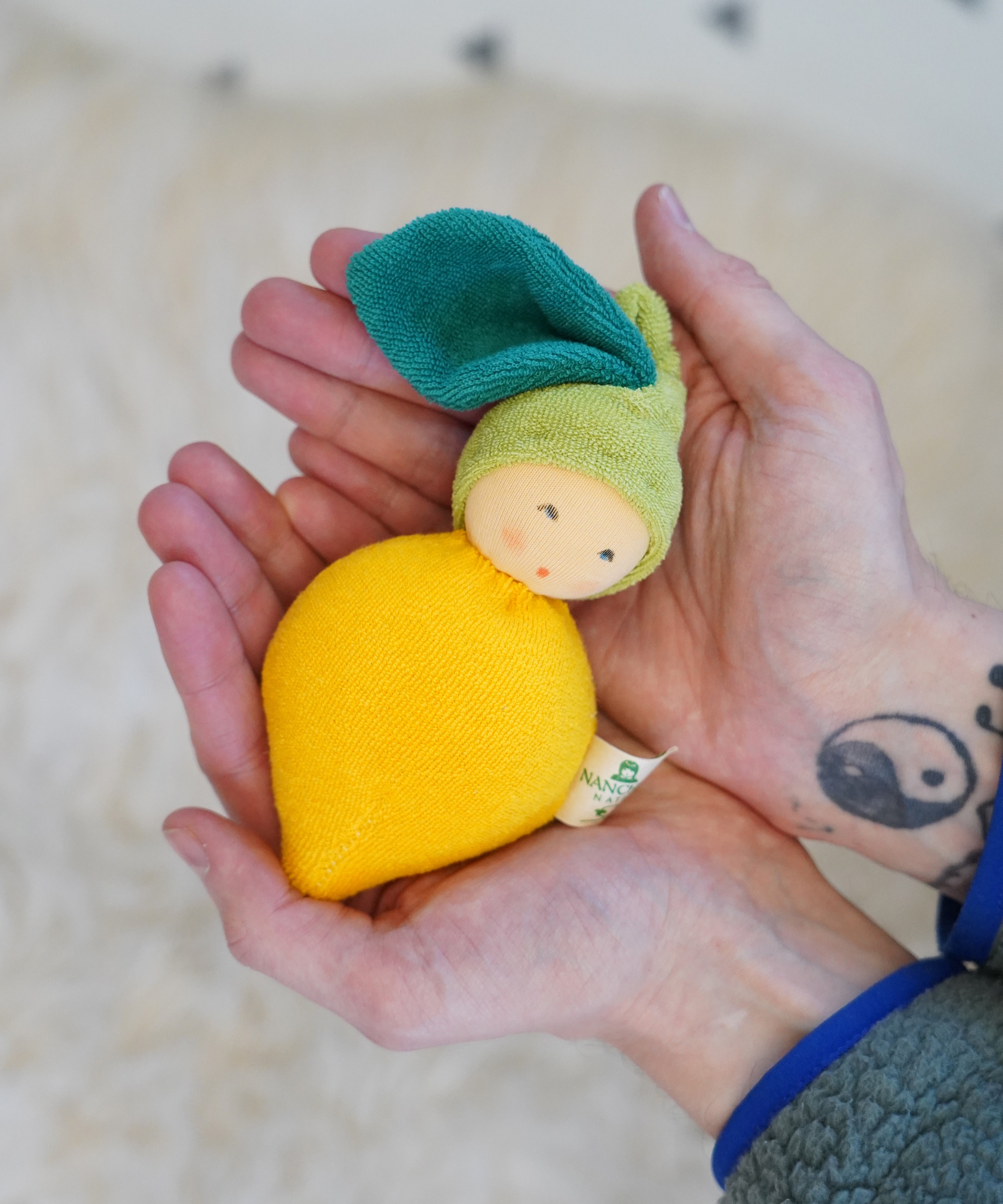 Nanchen Lemon Rattle Doll - organic doll in a persons hands.