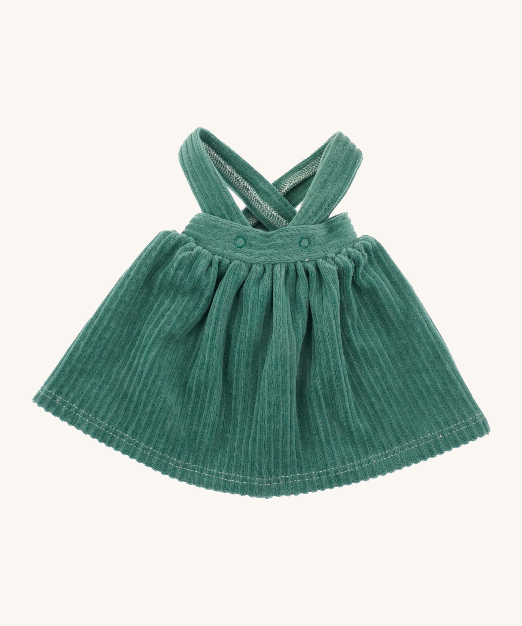 Nanchen Waldorf Doll - Lotte's green pinafore dress on a cream background 