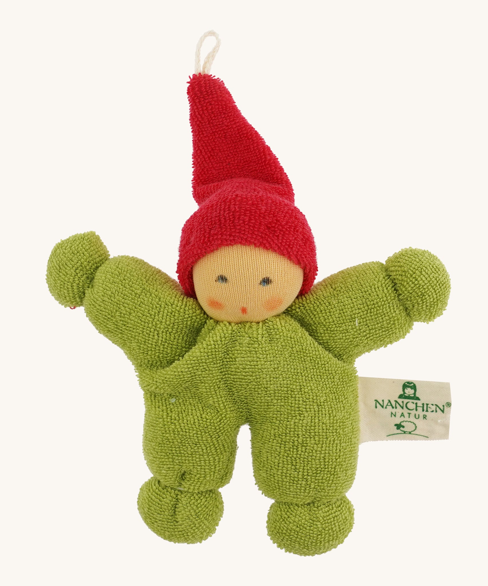 A little Nanchen gnome doll for the carry cot wearing a green onesie and a red hat on a cream background.