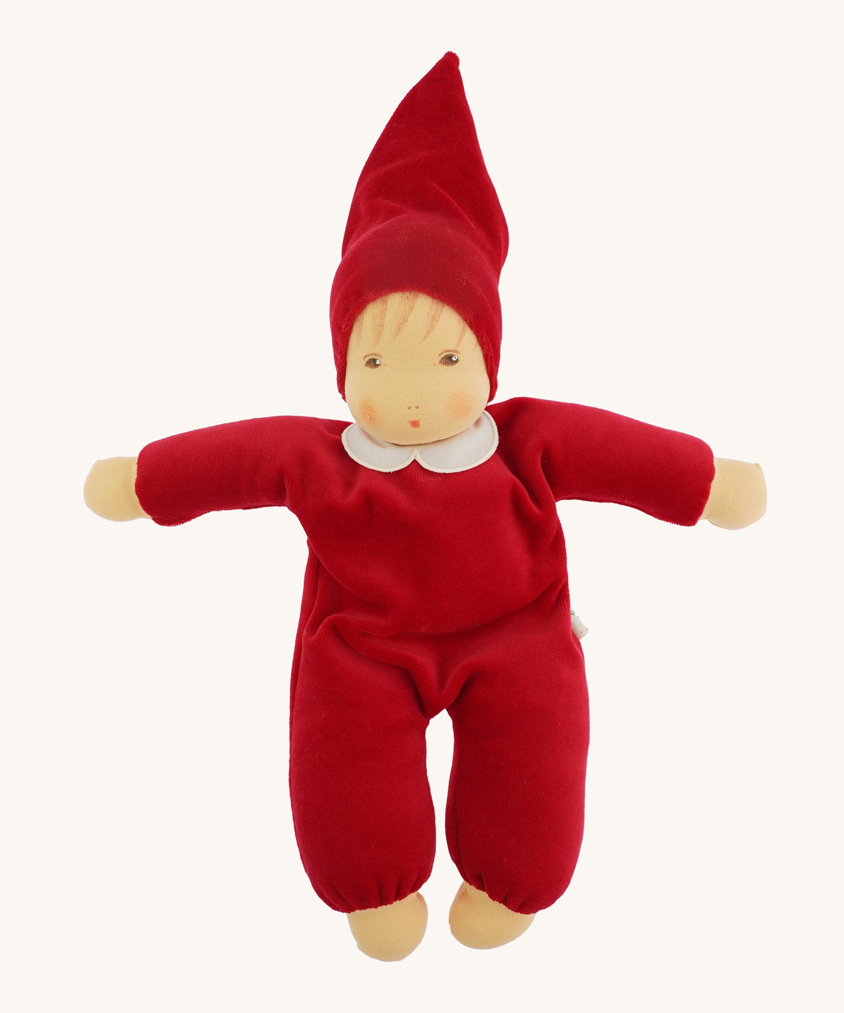 A beautiful Nanchen Waldorf Nani Doll, with a pretty hand painted face. This hand crafted doll toy has a red fabric, soft body with a small white collar and red pointy hat. On a cream background