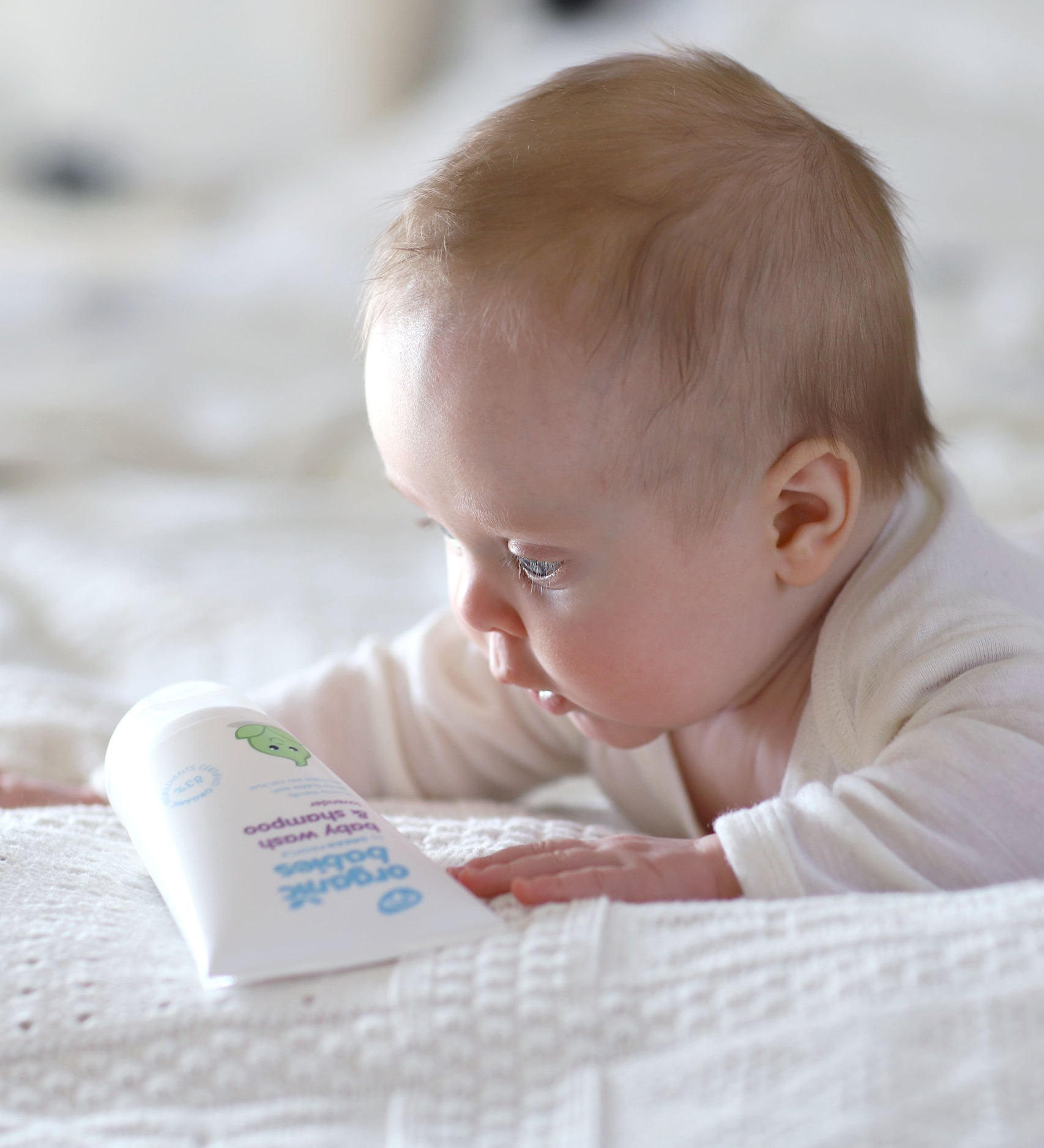 A baby looking down at the Lavender Green People Baby Wash & Shampoo