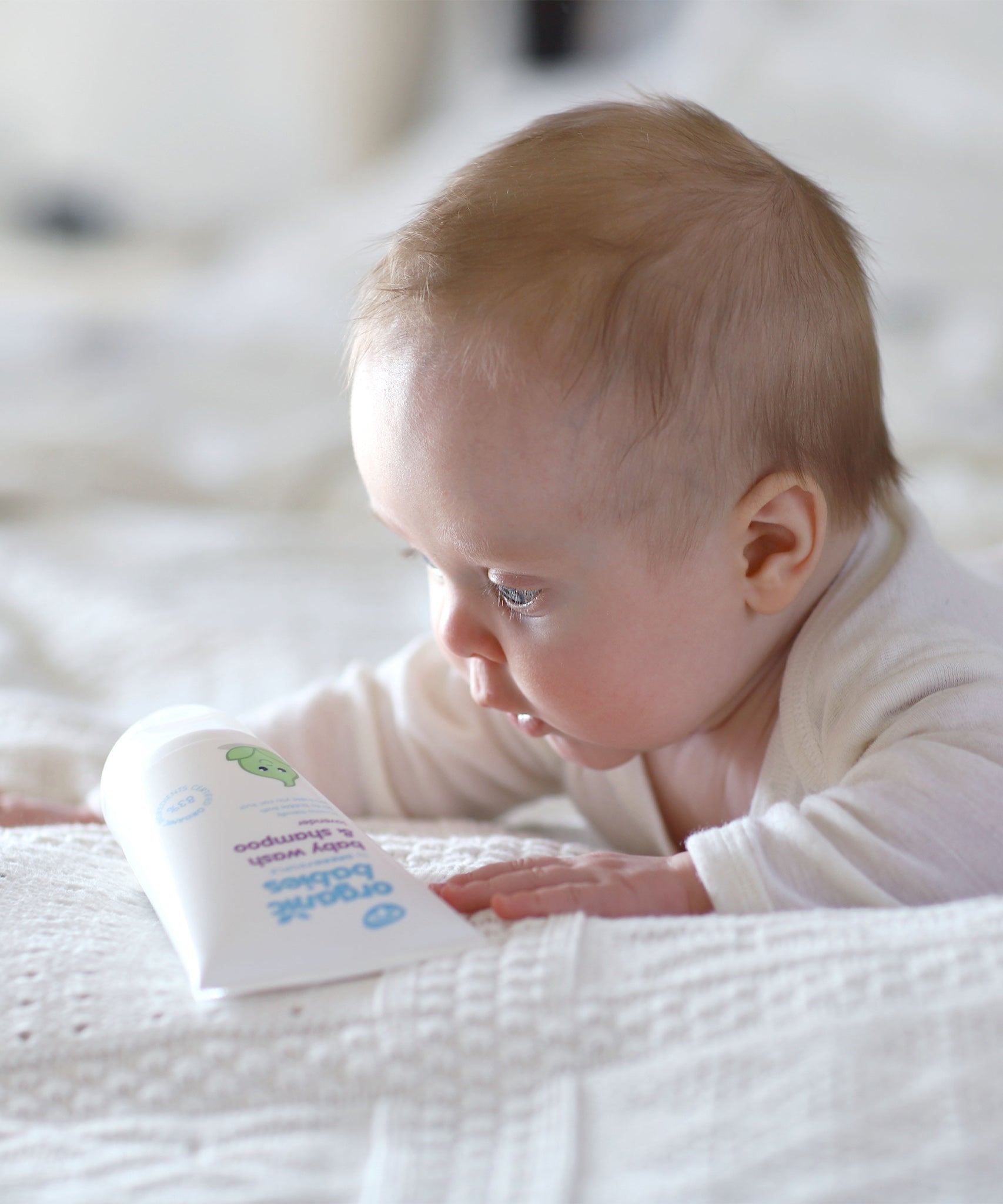 A baby looking down at the Lavender Green People Baby Wash & Shampoo