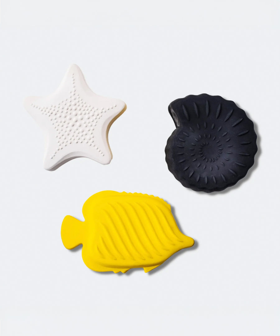 A child playing with the yellow fish bath toy from the Etta Loves Natural Rubber Animal Sensory Bath Toys - 3 Pack