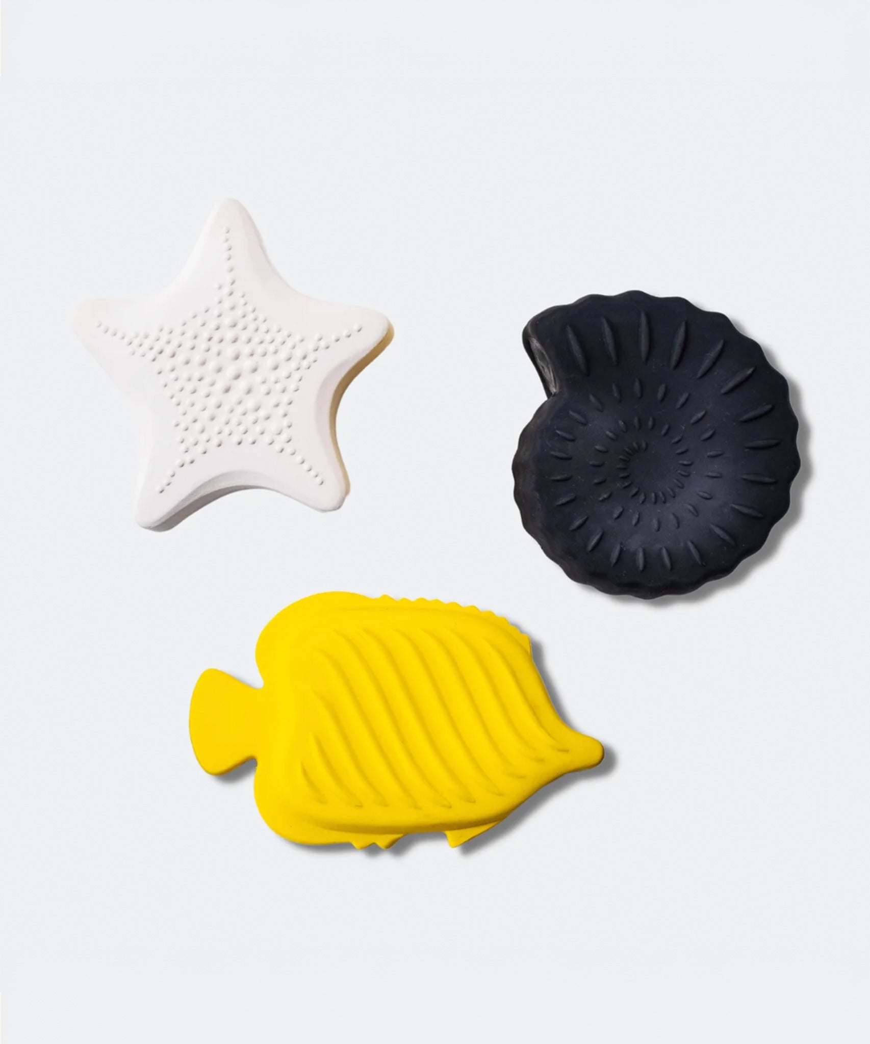 A child playing with the yellow fish bath toy from the Etta Loves Natural Rubber Animal Sensory Bath Toys - 3 Pack