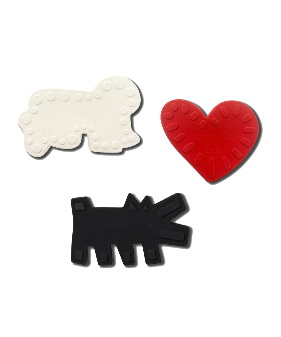 A child playing with the 'Baring Dog' bath toy from the Etta Loves X Keith Haring Natural Rubber Sensory Bath Toys - 3 Pack