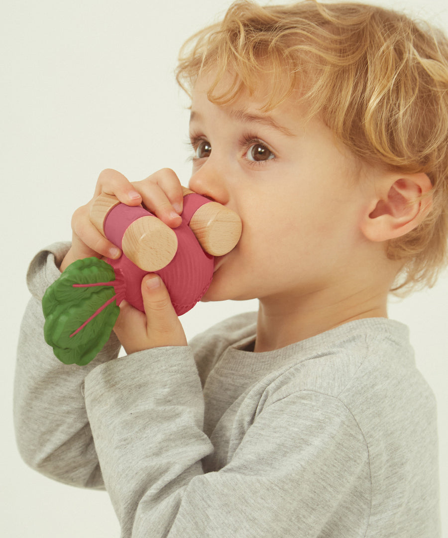 A child holding the Oli & Carol 100% Natural Rubber Car collection