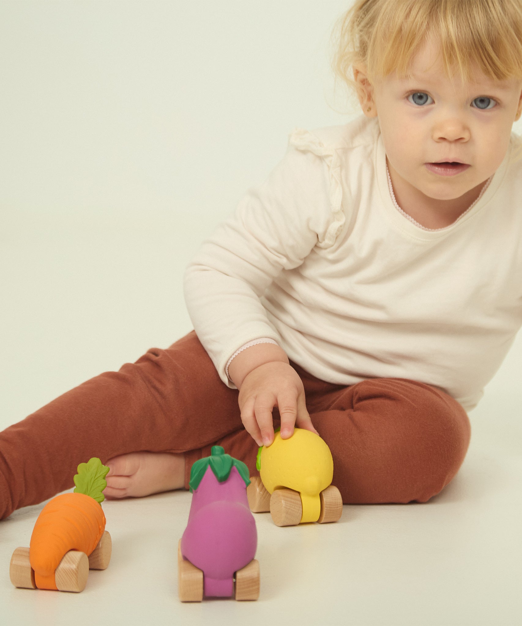 A child playing with the Oli & Carol 100% Natural Rubber Cars