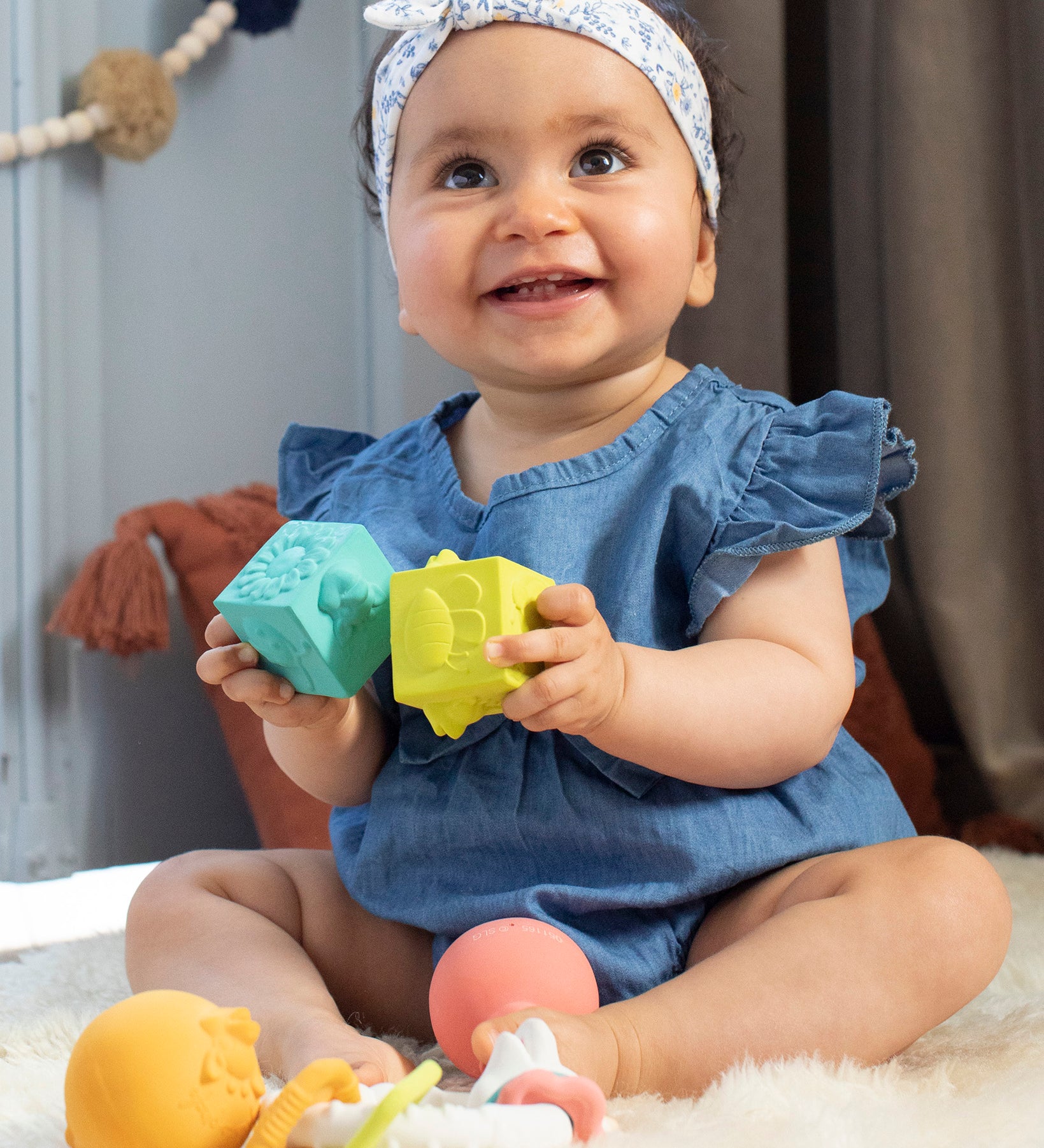 A child happily playing with the Sophie The Giraffe - So Pure Early Learning Gift Set