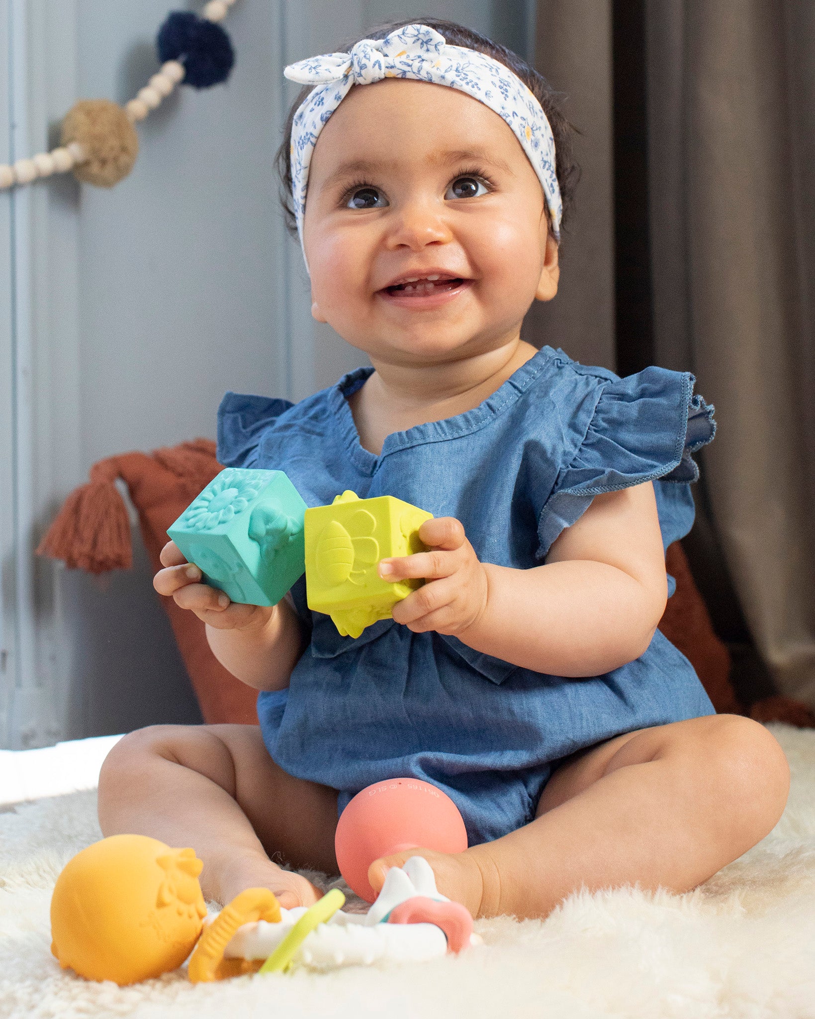 A child happily playing with the Sophie The Giraffe - So Pure Early Learning Gift Set