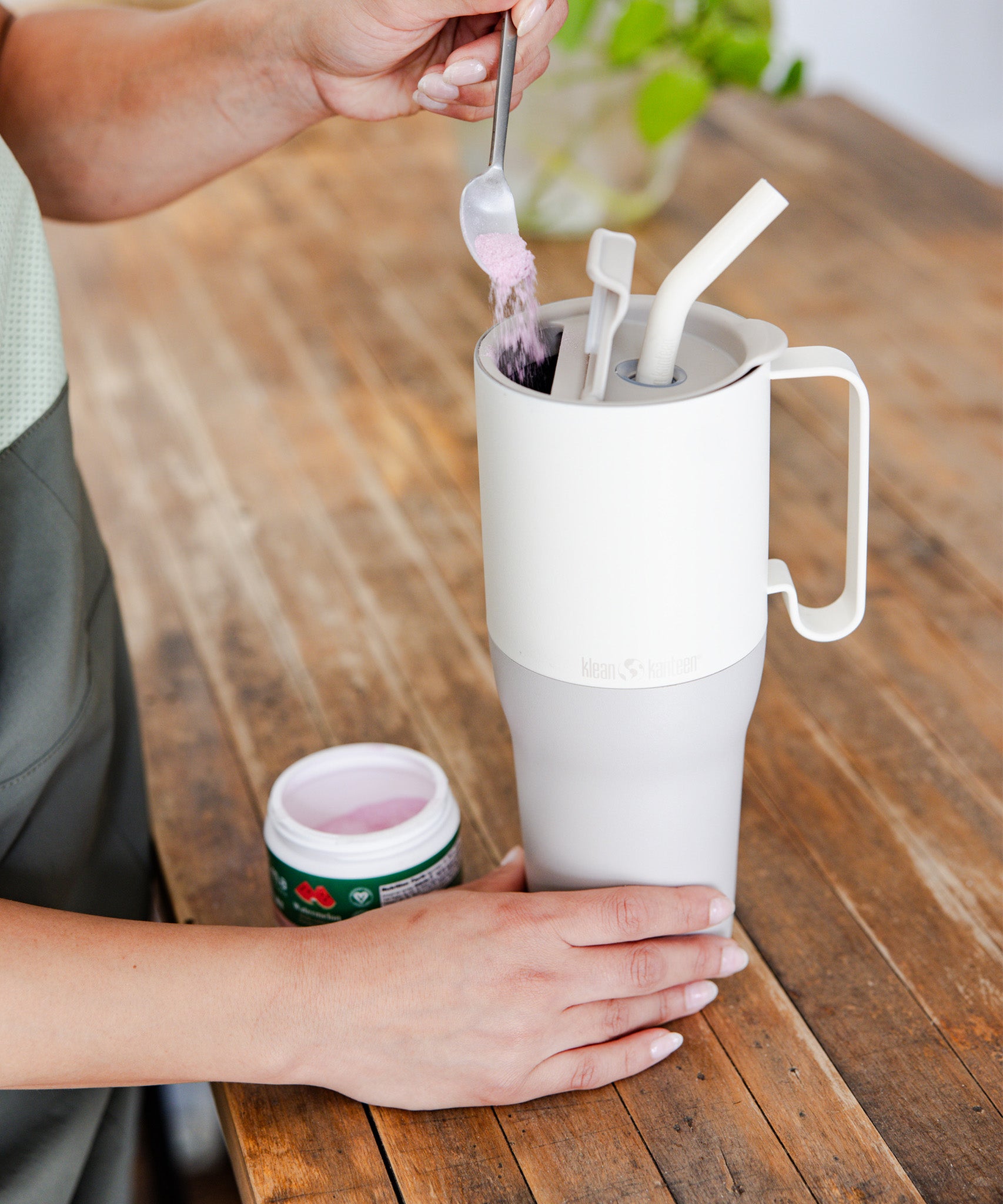 A close up of a white tofu coloured Klean Kanteen Limited Edition 36oz Rise Tumbler placed on a wooden counter top