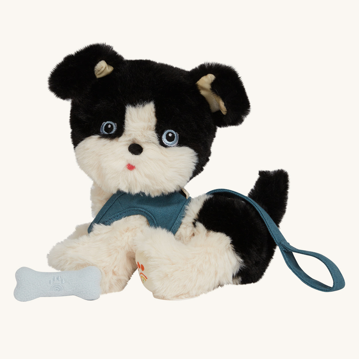 The Olli Ella Dinkum Dog "Lucky" is a dog shaped stuffed toy with soft black and white fur