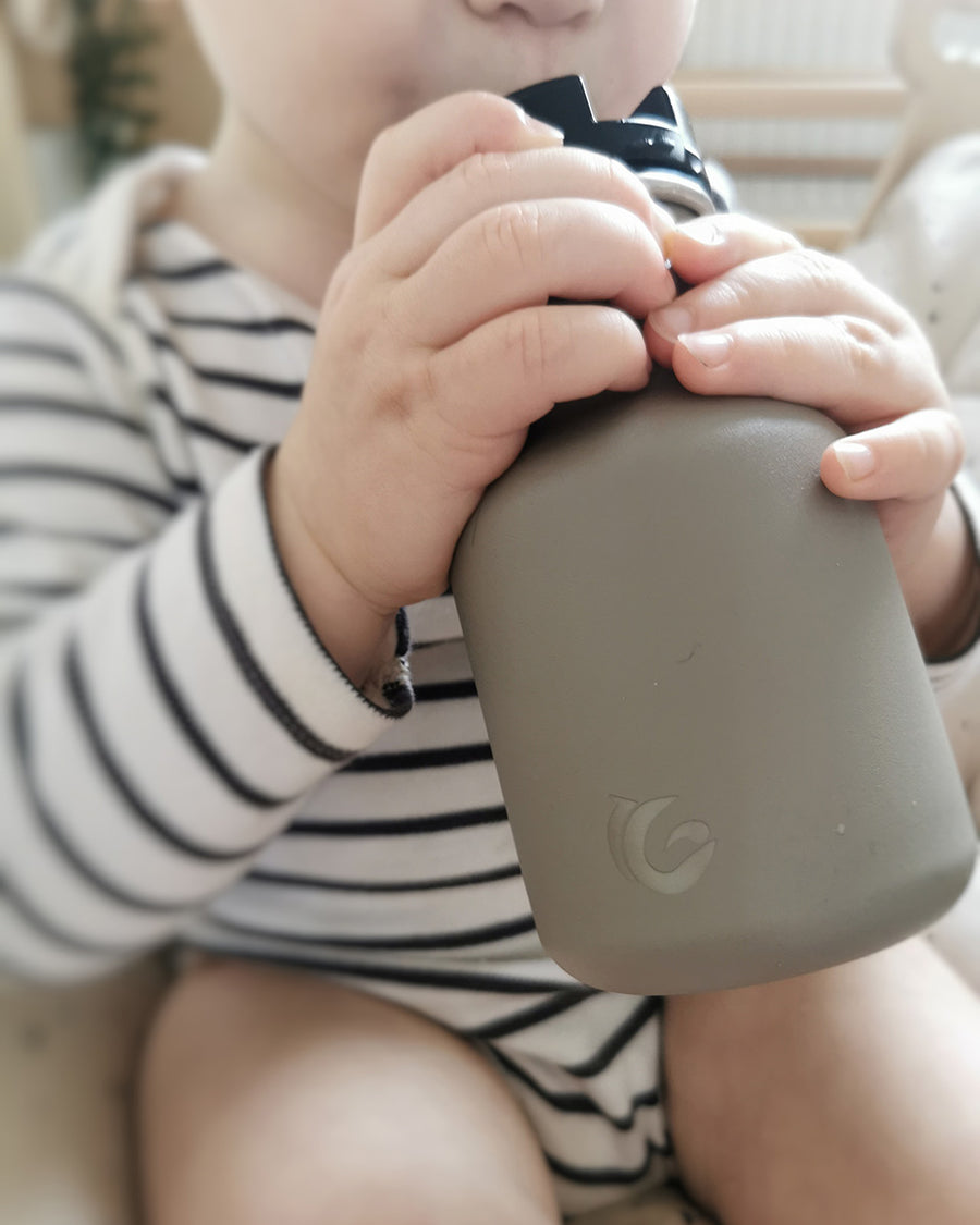 Close up of childs hands clutching the One Green Bottle eco-friendly metal water bottle 