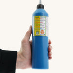 An adult's hand holding a 500ml bottle of OkoNorm finger paints in a blue colour. 