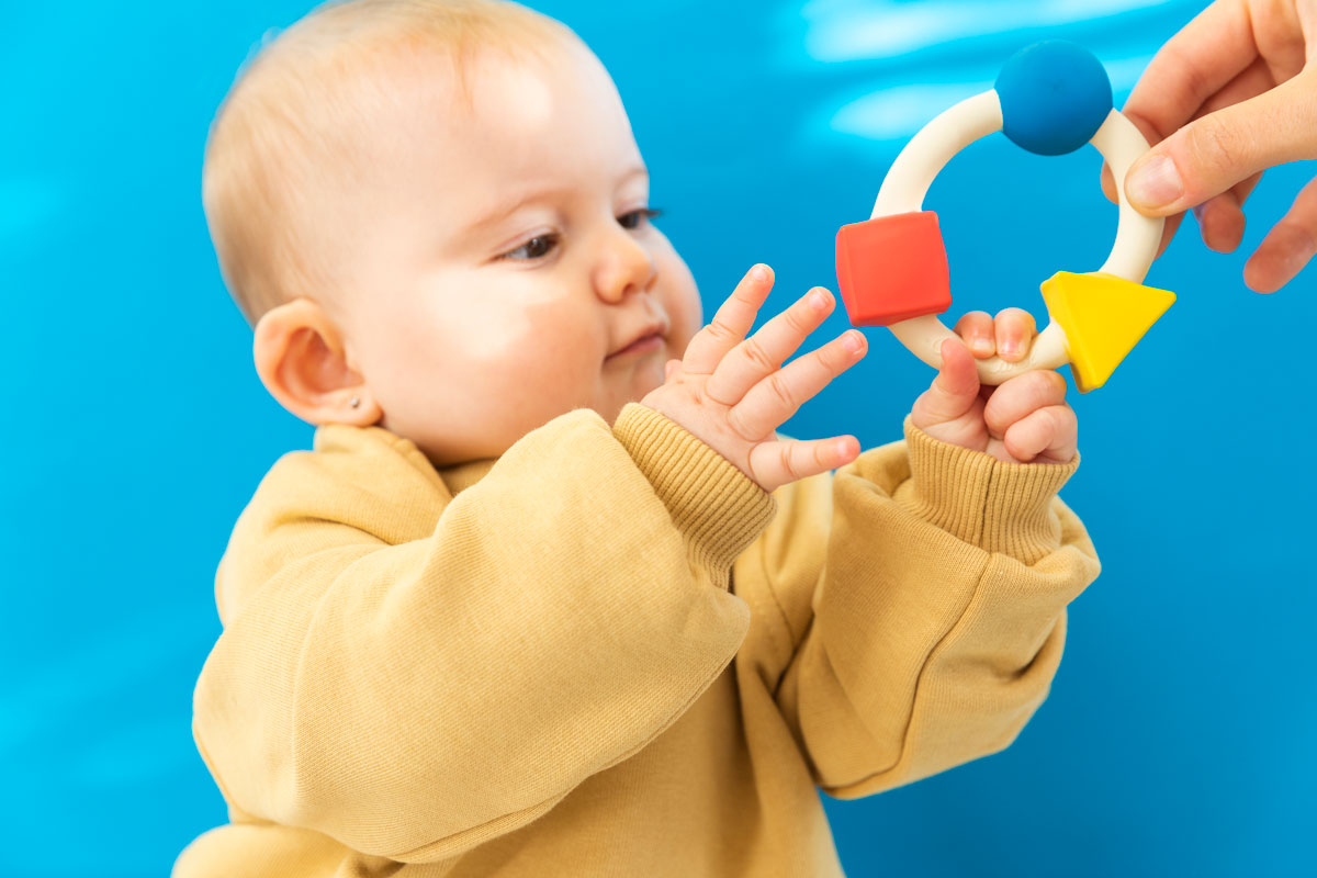 Side view of Oli & Carol X Bauhaus Movement Teething Ring pictured on a plain white background