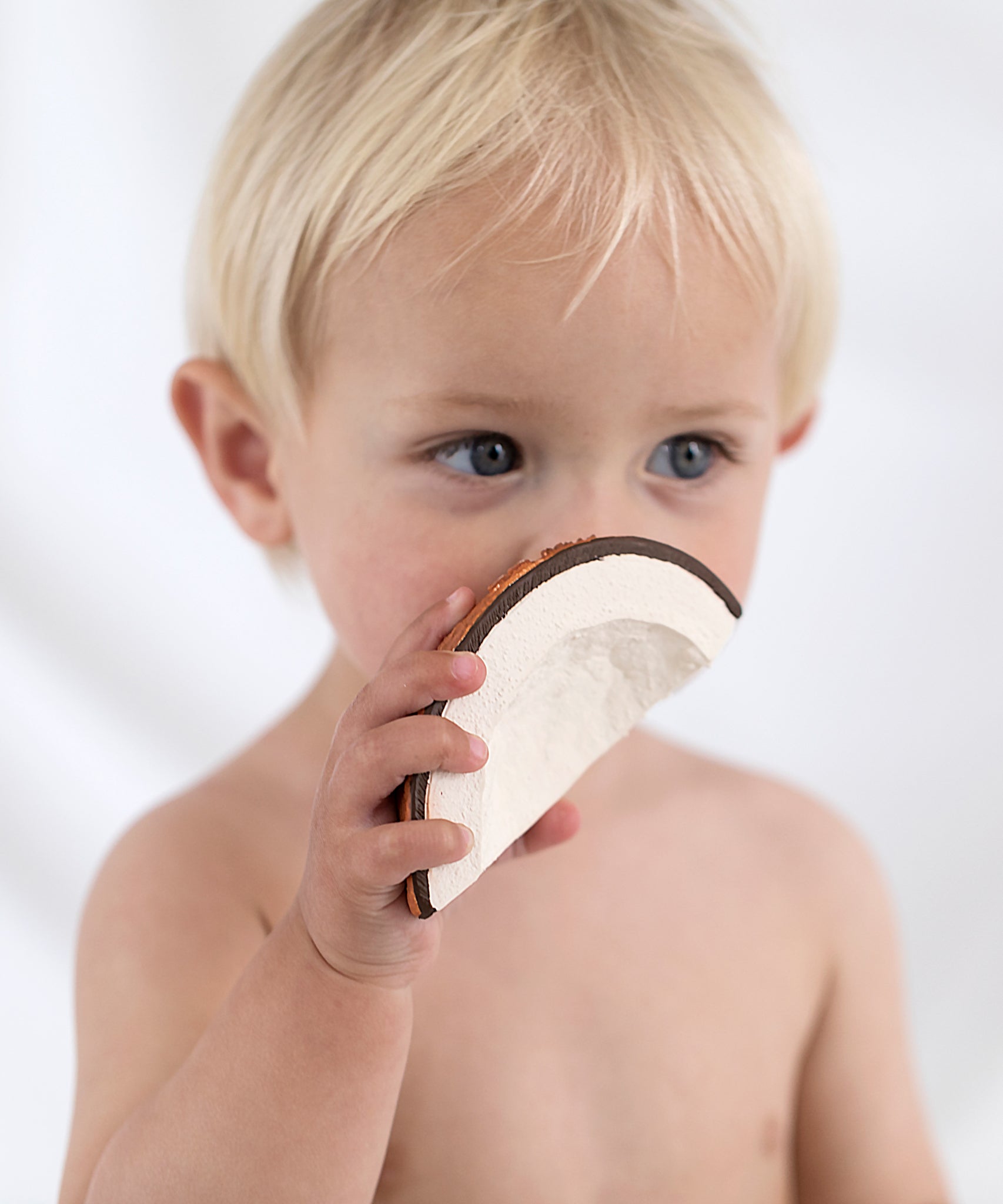 A child holding the Oli & Carol Coco The Coconut. 