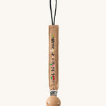 Oli & Carol Cool Kids Pacifier Clip, the words cool kids eat healthy written on a beige canvas with vegetable embroidery detail